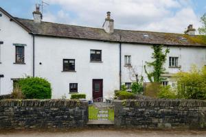 an old white house with a stone wall at Victory Cottage in Ambleside