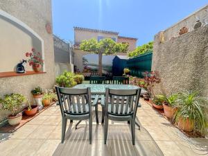 einen Tisch und Stühle auf einer Terrasse mit Topfpflanzen in der Unterkunft Maison avec jardin et parking, proche des plages in Fréjus