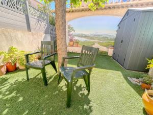zwei Stühle auf dem Rasen im Garten in der Unterkunft Maison avec jardin et parking, proche des plages in Fréjus + 2 Fotos