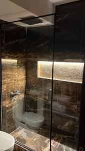 a bathroom with a glass shower with a toilet at Compound Gardaina city in Cairo