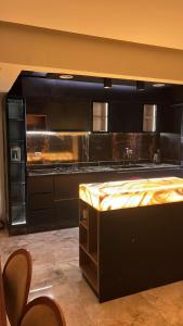 a kitchen with black cabinets and a sink at Compound Gardaina city in Cairo