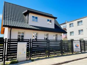 una casa con una valla negra al lado de un edificio en Dwie Sowy by Baltic Home, en Międzyzdroje 29 fotos más