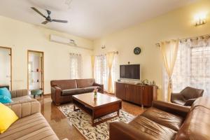 a living room with leather couches and a tv at Canvas43 Eco Villa DailyHK EVCharging in Bengaluru