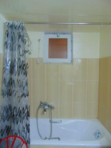 a bathroom with a tub and a shower curtain at Douja Apartment in Nabeul