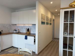 a kitchen with white cabinets and a table at GRADISSIMO in Grado-Pineta