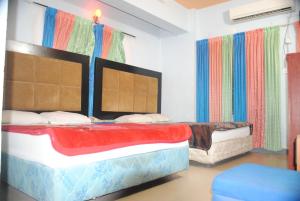 two beds in a room with colorful curtains at Hotel Sea Alif in Cox's Bazar