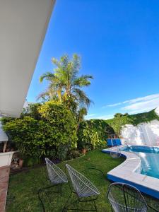 une cour avec des chaises et une piscine dans l'établissement "La Almagro", à San Fernando del Valle de Catamarca