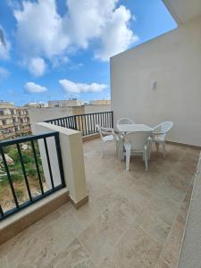 a patio with a table and chairs on a balcony at New Marsalforn Serenity Stay & Near Sea Apartment in Marsalforn