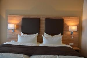 a bed with two pillows and two nightstands at Altstadthotel Harburg in Hamburg
