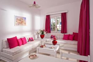 a living room with red curtains and a white couch at Galini Studios and Apartments in Malia +25 photos