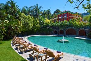 里斯本Pestana Palace Lisboa Hotel & National Monument - The Leading Hotels of the World的一座带躺椅的游泳池和一座建筑