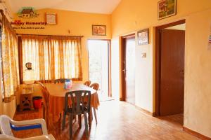 a dining room with a table and chairs and a window at Smiley Homestay Family-Friendly 3BR in Kodaikānāl