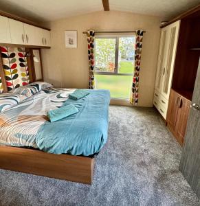 a bedroom with a large bed and a window at Tattershall Lakes 2 bedroom,6 berth Holiday home with hot tube in Tattershall +32 photos