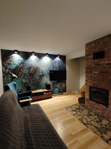 a living room with a couch and a fireplace at Leśny Relaks in Krasiejów