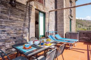 Un patio con una mesa y sillas en un balcón. en Casa Li Galli with sea view, en SantʼAgata sui Due Golfi