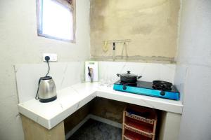 a kitchen with a stove and a tea kettle on a counter at Sepali House Nilwella in Dickwella