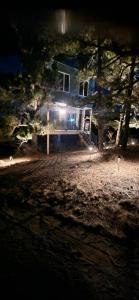 a house at night with lights in front of it at Rustic Treehouse in Peyton