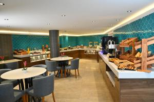 a restaurant with tables and chairs and a kitchen at Sogut Hotel Old City in Istanbul