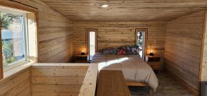 a bedroom in a log cabin with a bed and a table at Rustic Treehouse in Peyton