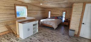 a bedroom with a bed in a log cabin at Rustic Treehouse in Peyton