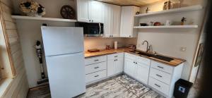 a kitchen with white cabinets and a white refrigerator at Rustic Treehouse in Peyton