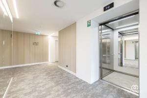 un corridoio vuoto con una porta a vetri in un edificio di Apartament Premium Baltic View-Pinea Apartments Pobierowo-morze na wyciągnięcie ręki!-dostęp do strefy basenów,saun i jacuzzi-SANNEL Apartments for rent a Pobierowo
