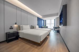 Ένα ή περισσότερα κρεβάτια σε δωμάτιο στο Atour Hotel Kunming Guandu Longhu Times Financial Center