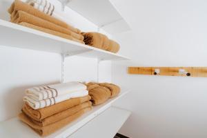 a pile of towels on shelves in a bathroom at Ferienhaus mit Sauna in Bad Gastein +75 photos