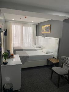a bedroom with a large bed and a chair at Beyhan Hotel in Istanbul