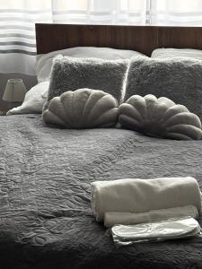 a bed with two pillows on top of it at Piemona Mini Apartman in Miskolc