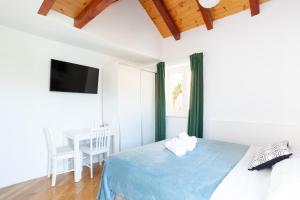 a bedroom with a bed and a table and a television at Orsan Residence Apartment in Dubrovnik