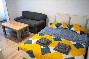 una camera da letto con un letto, un divano e un tavolo di Studio Targoviste a Târgovişte