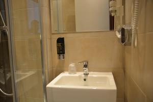 a bathroom with a sink and a shower at Altstadthotel Harburg in Hamburg