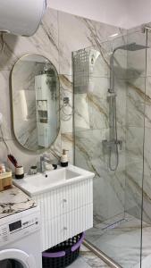 een badkamer met wastafel en douche met spiegel bij Deluxe Apartment in Fier +19 foto's