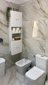 een witte badkamer met een toilet en een wastafel bij Deluxe Apartment in Fier