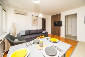 a living room with a couch and a table at Modern 1 BDR with Balcony in Sarajevo
