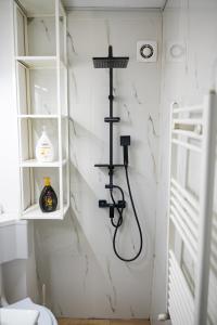 una doccia in un bagno con una parete bianca di Studio Targoviste a Târgovişte