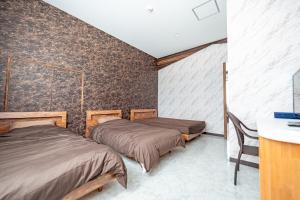 due letti in una stanza con una parete di Resort in青の洞窟 a Isola di Ishigaki