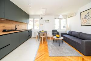 a kitchen and living room with a couch and a table at Modern 1 BDR with Balcony in Sarajevo