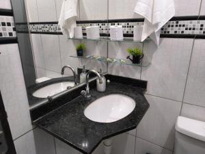 a bathroom with a sink and a toilet at Casa Grande com área Gourmet e Garagem in Montes Claros