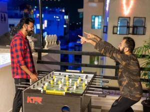 two men standing next to a table with a chessboard at The Hosteller Udaipur in Udaipur