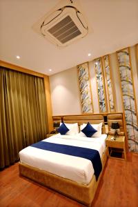 KhātuThe GM Hotel的卧室里有一张大床，配有蓝色枕头