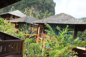 a group of houses with a mountain in the background at Avatar Railay in Railay Beach