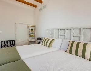 a white couch with green and white pillows in a room at VELALMA-CERON Edificio exclusivo de apartamentos turisticos en Centro histórico in Jaén