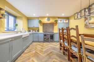 a large kitchen with blue cabinets and wooden floors at Boutique Stays at 56 in Newtownards