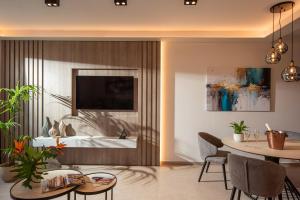 a living room with a dining table and a television at Theatro Living in Elegance - Luxury Apartments in Hersonissos in Hersonissos