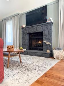 a living room with a stone fireplace with a flat screen tv at Pocono Chalet,Hot Tub,Arcade,Fireplace, Lake,Pool, Pet friendly, near Jim Thorpe No extra fees to use amenities in Towamensing Trails