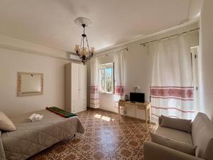 a bedroom with a bed and a couch and a chandelier at Casa sulla Piazzetta in Olbia