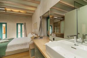 een badkamer met een bed, een wastafel en een spiegel bij Panaretos Deluxe Maisonette in Chania
