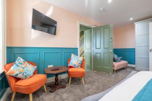 a bedroom with a bed and two chairs and a table at Boutique Stays at 56 in Newtownards